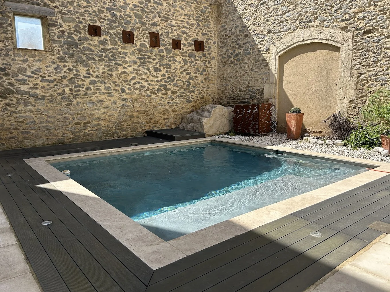 Piscine de La Belle Éclusière entourée de murs en pierre